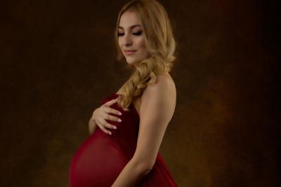 Expectant mother draped in red sheet