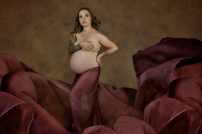 Expectant mother wrapped in red flowy sheet
