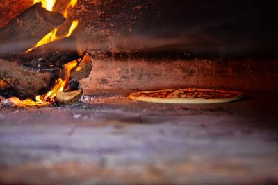 Fresh pizza baking in wood pizza oven