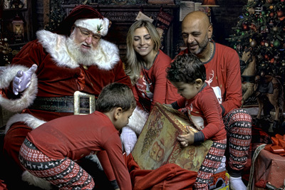 Family opening Christmas gifts with Santa