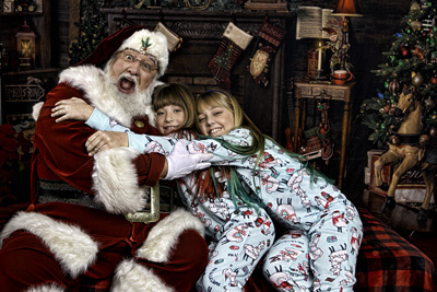 Two girls hugging santa